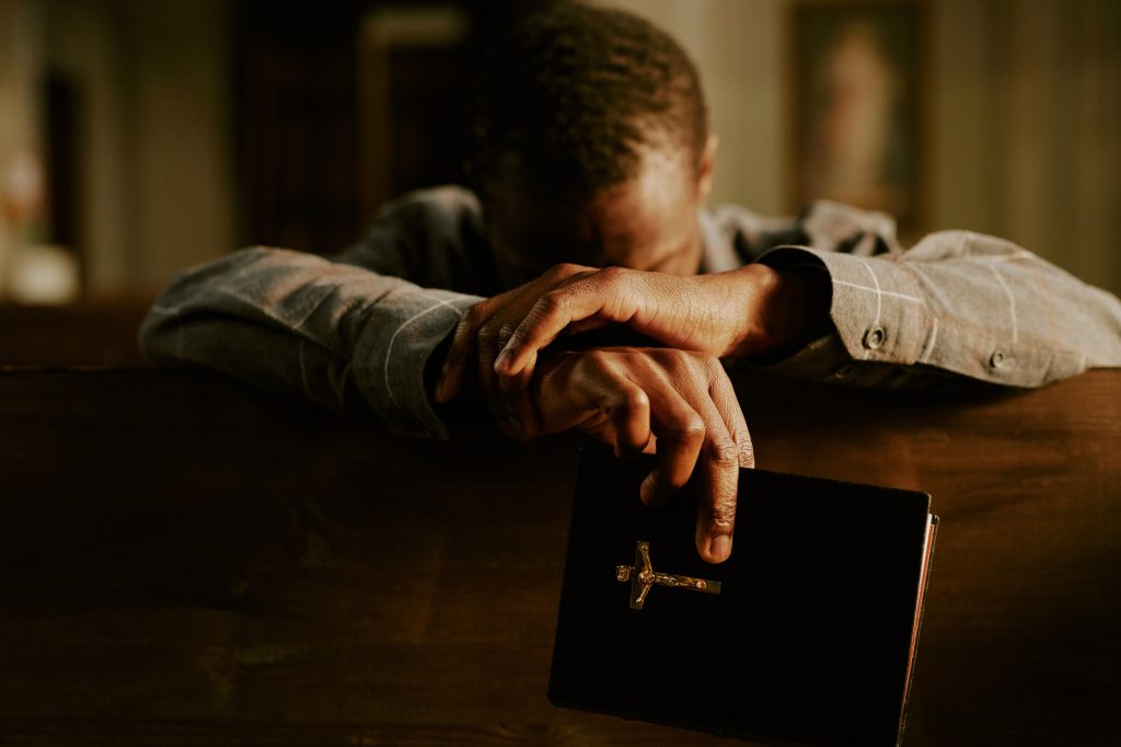 Unrecognizable Black Man Praying